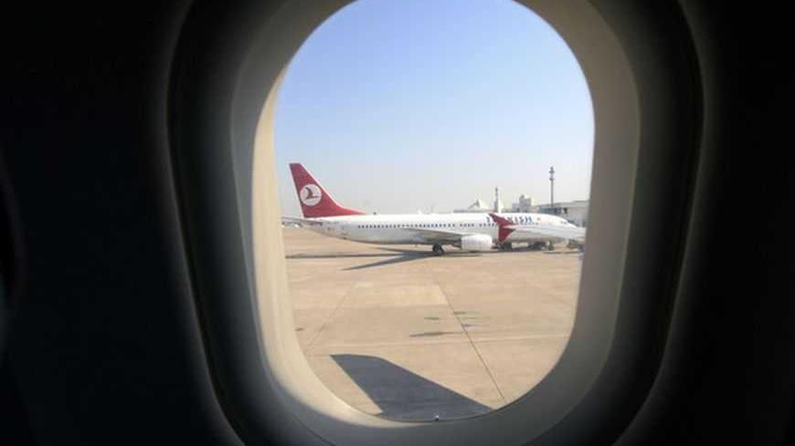 A Turkish Airlines Boeing 737 is seen through a window of another passenger plane at the airport in the Mediterranean coastal city of Antalya August 9, 2007. Turkish Airlines staff have been balloted this week on whether to strike for more pay at the height of the tourist season.   REUTERS/Fatih Saribas  (TURKEY) - RTR1SN2P