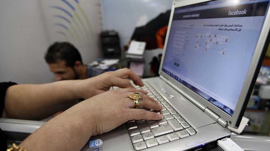 A woman uses wireless Internet at an internet shop in Baghdad November 10, 2012. Iraqi telecommunications operators have warned that government plans to charge for the extra spectrum which they need to launch long-awaited 3G services could slow Internet adoption and economic growth. Picture taken November 10, 2012 . To match story IRAQ-TELECOMS/  REUTERS/Mohammed Ameen (IRAQ - Tags: SCIENCE TECHNOLOGY BUSINESS TELECOMS SOCIETY) - RTR3ADY1