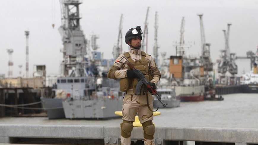 An Iraqi soldier stands guard during a ceremony to receive two American- built vessels at Iraq's southern province of Basra, December 20, 2012. Iraqi navy received on Thursday the first two American-built vessels to boost surface force martial and secure the largest oil and commercial port in southern rich oil city of Basra. Ceremony took place on military base in Umm Qasr port south of Basra attended by Iraqi and U.S. military commanders and officials. Iraq and United States signed a contract late on 2009 