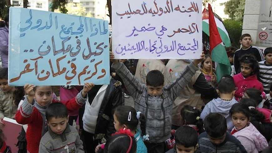 Palestinian children who were living in the Yarmouk Palestinian refugee camp before fleeing Syria, hold up banners during a protest in front of the International Committee of the Red Cross (ICRC) in Beirut January 17, 2013. Banners read, "The International Committee of the Red Cross is the conscience of the international community towards refugees" (R) and "Why the international community miserly to some places, and generous in some others?".  REUTERS/Sharif Karim (LEBANON - Tags: SOCIETY IMMIGRATION POLITI