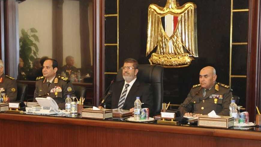Egyptian President Mohamed Mursi (C) sits next to the head of the Egyptian military General Abdel Fattah al-Sisi (3rd L) and top military and police chiefs during their meeting in Cairo February 4, 2013. REUTERS/Egyptian Presidency/Handout (EGYPT - Tags: POLITICS MILITARY) 

ATTENTION EDITORS - THIS IMAGE WAS PROVIDED BY A THIRD PARTY. FOR  EDITORIAL USE ONLY. NOT FOR SALE FOR MARKETING OR ADVERTISING CAMPAIGNS. ATTENTION EDITORS - THIS IMAGE WAS PROVIDED BY A THIRD PARTY. FOR  EDITORIAL USE ONLY. NOT FOR