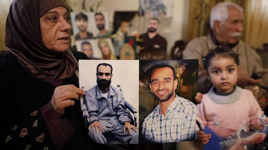 Layla al-Issawi holds a picture of her son Samer, who has been on hunger strike for 209 days while being held in an Israeli prison, at her home in the East Jerusalem neighbourhood of Issawiya February 17, 2013. The European Union on Saturday called on Israel to improve conditions for Palestinians in its jails, and a Palestinian minister said there would be rallies next week to support hunger-striking prisoners. Nearly 5,000 Palestinians are held in Israeli jails, many charged with involvement in attacks on 