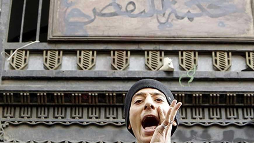 A protester shouts in front of the sign for the court of cassation during an anti-government protest in Cairo February 22, 2013. President Mohamed Mursi on Thursday called parliamentary elections that will begin on April 27 and finish in late June, a four-stage vote that the Islamist leader hopes will conclude Egypt's turbulent transition to democracy. REUTERS/Mohamed Abd El Ghany (EGYPT - Tags: POLITICS CIVIL UNREST) - RTR3E4P9
