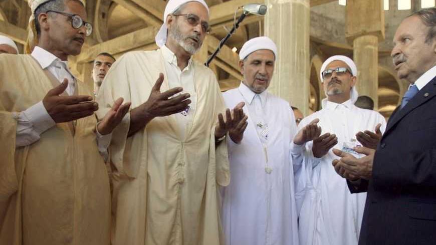 Algeria's President Abdelaziz Bouteflika (R) prays with imams at a mosque's building site during his official visit  to Oran August 1, 2007. REUTERS/Zohra Bensemra (ALGERIA) - RTR1SFNJ