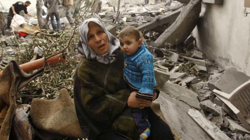 A Palestinian woman sits on the rubble of her destroyed house after an Israeli air strike in Rafah in the southern Gaza Strip December 30, 2008. Israel rejected any truce with Hamas Islamists on Tuesday and said it was ready for "long weeks of action" on a fourth day of the fiercest air offensive in the Gaza Strip in decades. REUTERS/Ibraheem Abu Mustafa (GAZA) - RTR22XFB