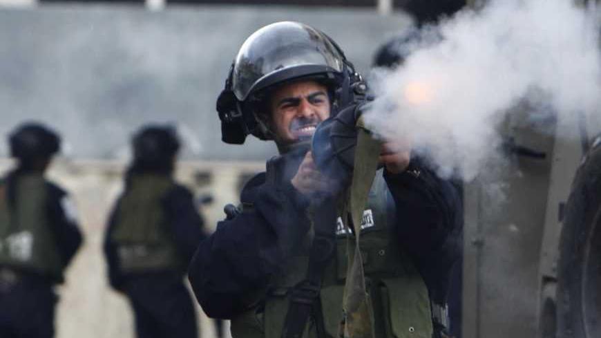 An Israeli policeman fires a tear gas canister during clashes with Palestinian protesters at a demonstration against the closure of Shuhada street to Palestinians, in the West Bank city of Hebron February 24, 2012. Some 200 protesters, including foreign and Israeli activists, gathered on Friday marking the 18th anniversary of the closure of the street, which was closed by the Israeli army in 1994 following the Hebron mosque massacre by Baruch Goldstein, an Israeli settler, who went on a rampage inside Al Ib