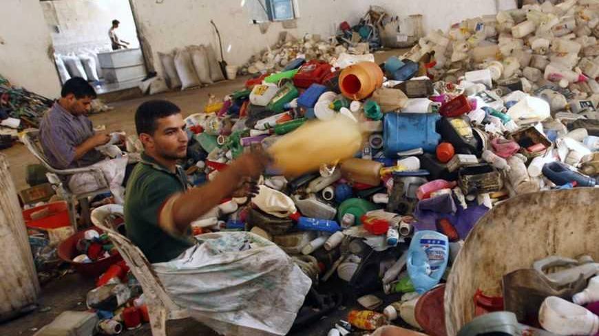 Palestinian labourers sort plastic containers before they are recycled in a factory in Abasan in the southern Gaza Strip October 25, 2009. REUTERS/Ibraheem Abu Mustafa (GAZA POLITICS ENVIRONMENT) - RTXPZTI