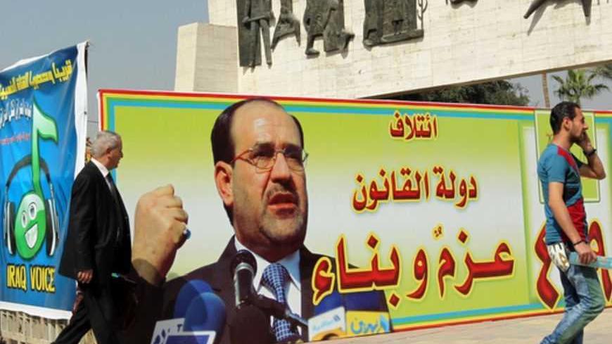 People walk past a campaign poster featuring Iraqi Prime Minister Nuri al-Maliki and announcing the provincial elections on March 2, 2013 near Tahrir Square in Baghdad. The elections will take place in April amid a political crisis in Iraq that has pitted Nuri al-Maliki against several of his erstwhile government partners and tensions have been heightened by the protests.   AFP PHOTO SABAH ARAR        (Photo credit should read SABAH ARAR/AFP/Getty Images)