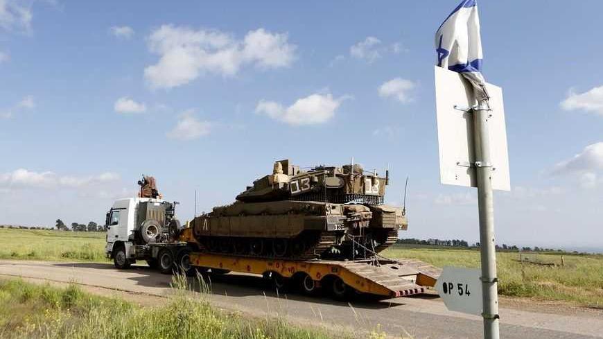 An Israeli tank is transported on a truck to the Israeli Syrian border in the Israeli-occupied Golan Heights March 24, 2013. Israel said it fired into Syria on Sunday and destroyed a machinegun position in the Golan Heights from where shots had been fired at Israeli soldiers in a further spillover of the Syrian civil war along a tense front. Israel captured the Golan Heights in the 1967 Middle East war and annexed it in 1981 in a move not recognized internationally. REUTERS/Baz Ratner (MILITARY POLITICS) - 