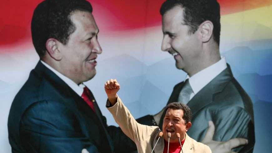 Venezuela's President Hugo Chavez delivers a speech during a visit to Sweida city, south of Damascus September 4, 2009. Sweida is the hometown of most of the Syrian immigrants who live in Venezuela. The poster in the background shows Chavez and Syria's President Bashar al-Assad .REUTERS/Khaled al-Hariri    (SYRIA POLITICS) - RTR27FQG