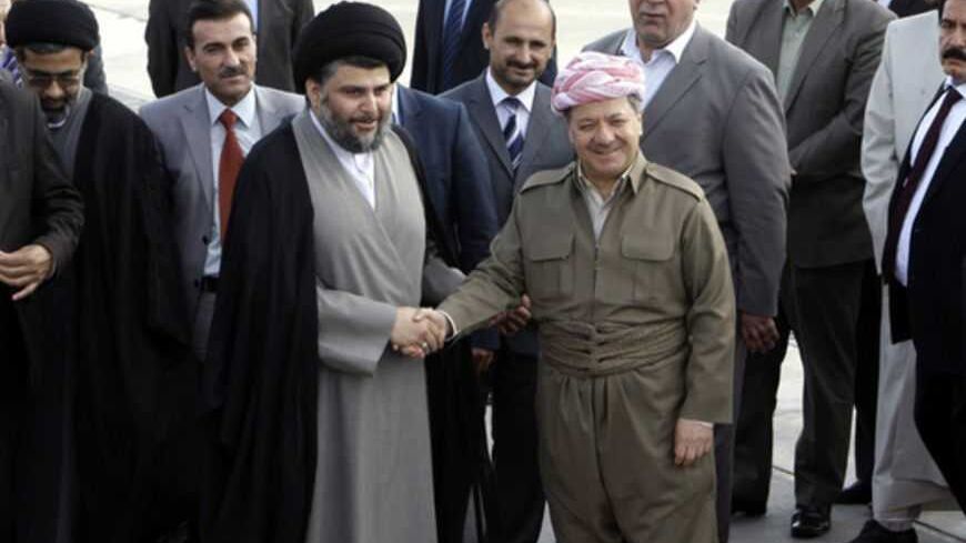 Iraqi Kurdish regional President Masoud Barzani (R) welcomes Iraqi Shi'ite cleric Moqtada al-Sadr at Arbil's airport, about 350 km (220 miles) north of Baghdad April 26, 2012.  REUTERS/Azad Lashkari (IRAQ - Tags: POLITICS) - RTR3194S