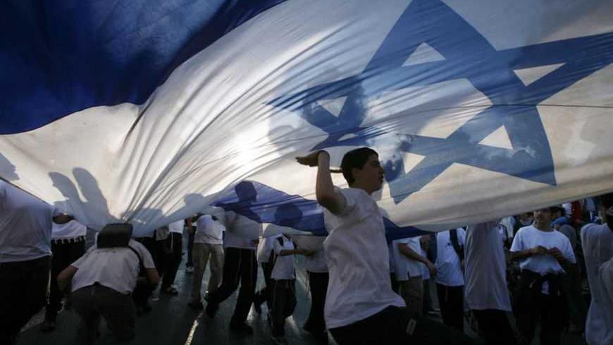 Israeli youths dance under a huge national flag during a parade marking Jerusalem Day in Jerusalem May 20, 2012. Jerusalem Day marks the anniversary of Israel's capture of the Eastern part of the city during the 1967 Middle East War. Israel annexed East Jerusalem as part of its capital in a move not recognized internationally. REUTERS/Baz Ratner (JERUSALEM - Tags: POLITICS ANNIVERSARY TPX IMAGES OF THE DAY) - RTR32D2U