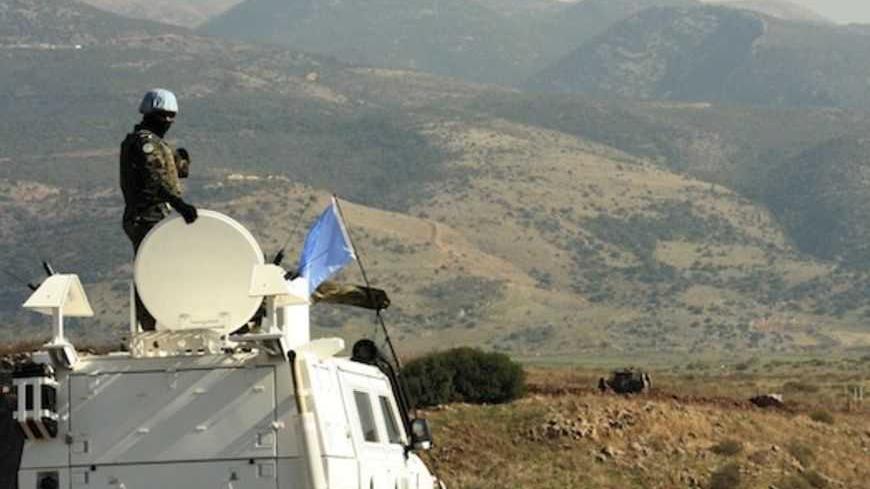 A United Nations (U.N.) peacekeeper on an armoured vehicle patrols the Wazzani area, where Israeli military forces are constructing a new position, as seen from the southern Lebanese village of Wazzani, near the Lebanese-Israeli border in south Lebanon November 28, 2012. Hezbollah leader Sayyed Hassan Nasrallah warned Israel on Sunday that thousands of rockets would rain down on Tel Aviv and cities across the Jewish state if it attacked Lebanon. REUTERS/ Karamallah Daher (LEBANON - Tags: MILITARY POLITICS T