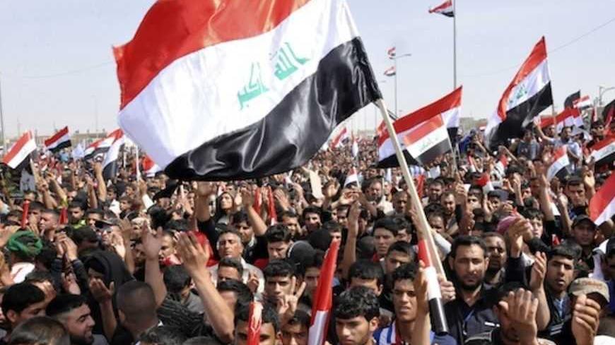 Supporters of Shi'ite cleric Moqtada al-Sadr carry Iraqi national flags during a rally, which the participants said was against sectarianism and injustice, in Kut, 150 km (93 miles) southeast of Baghdad, March 16, 2013.    REUTERS/Wissm al-Okili (IRAQ - Tags: CIVIL UNREST) - RTR3F2NC