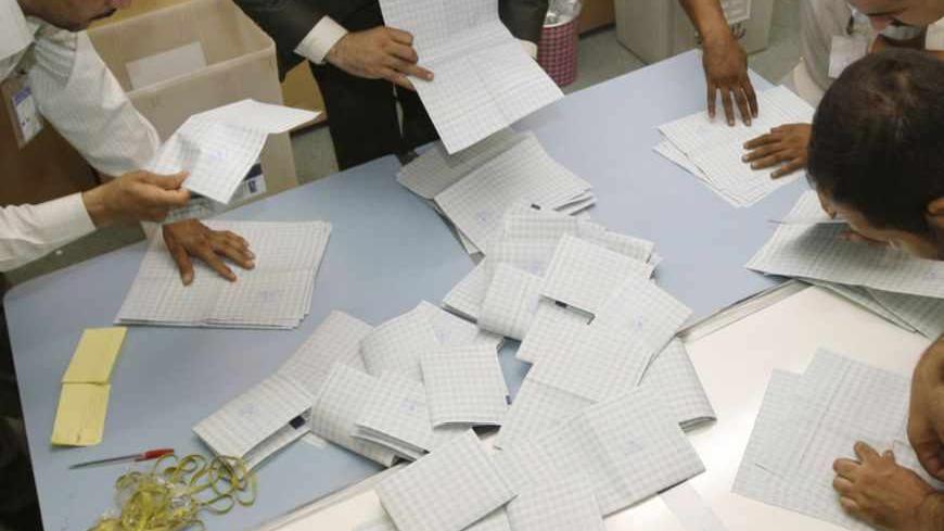 Electoral workers tally ballots after the end of voting in a polling station in Baghdad, July 25, 2009. Iraqi Kurds voted on Saturday in elections expected to keep President Masoud Barzani in power in Kurdistan and unlikely to allay voters' worries about corruption or end a feud with Baghdad over land and oil.   REUTERS/Mohammed Ameen (IRAQ ELECTIONS POLITICS ENERGY) - RTR261N3