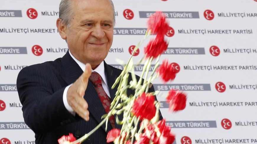 Nationalist Movement Party (MHP) leader Devlet Bahceli hands out carnations during an election rally in Ankara June 4, 2011. Turkey will hold parliamentary elections on June 12. REUTERS/Umit Bektas (TURKEY - Tags: ELECTIONS POLITICS) - RTR2NA75