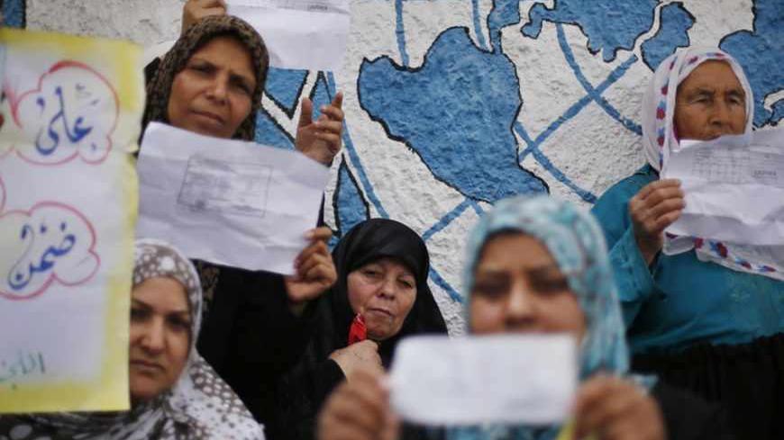 Palestinian women hold up their refugee ration cards during a protest demanding the United Nations Relief and Works Agency (UNRWA) to resume aid for refugees in Gaza City April 8, 2013. The main U.N. humanitarian agency for Palestinians closed all of its relief and distribution centres in Gaza after protesters stormed its headquarters on Thursday demanding it to reverse a decision to cut annual cash handouts of $40 to the poorest beneficiaries. REUTERS/Suhaib Salem (GAZA - Tags: POLITICS CIVIL UNREST SOCIET