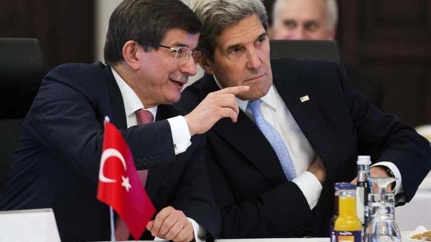 U.S. Secretary of State John Kerry (R) talks with Turkish Foreign Minister Ahmet Davutoglu during a "Friends of Syria" group meeting hosted by Davutoglu at the Adile Sultan Palace in Istanbul April 20, 2013. The U.S. plans to provide about $100 million in new aid to the Syrian opposition that could mean an expansion of non-lethal military assistance for certain rebel groups to include body armor and night-vision goggles, a U.S. official said on Friday. REUTERS/Evan Vucci/Pool (TURKEY - Tags: POLITICS CONFLI