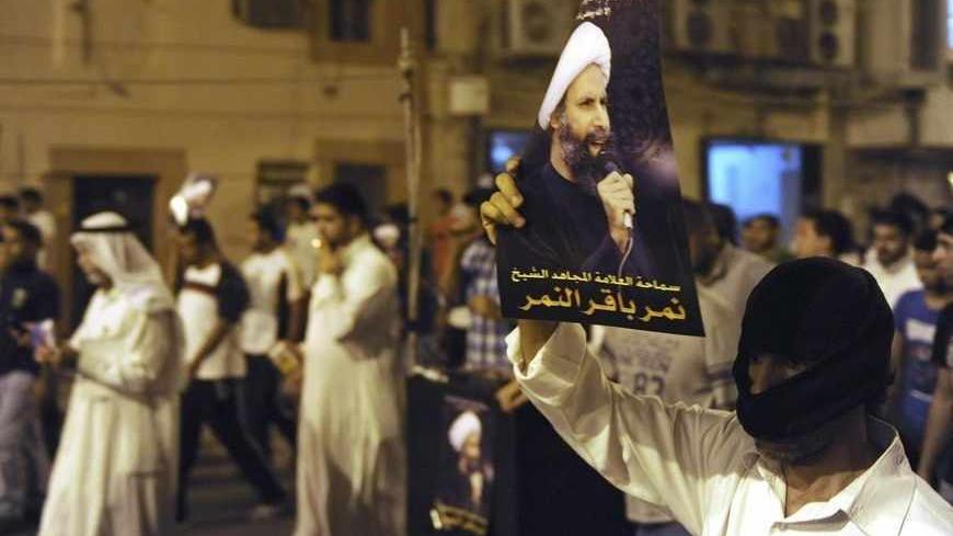 A protester holds up a picture of Sheikh Nimr al-Nimr during a rally at the coastal town of Qatif, against Sheikh Nimr's arrest July 8, 2012. Sheikh Nimr, a prominent Shi'ite Muslim cleric who was wanted by the police, was detained in Saudi Arabia's Eastern Province on Sunday over calls for more rights for the minority Muslim sect in the Sunni monarchy, his brother and an activist said. REUTERS/Stringer (SAUDI ARABIA - Tags: CIVIL UNREST RELIGION POLITICS) - RTR34QU6
