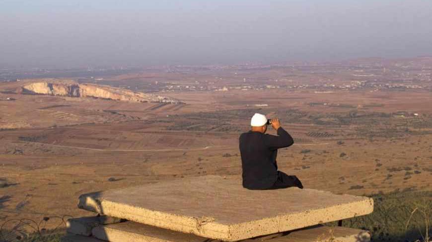 A Druze man uses binoculars as he looks towards Syria from part of an abandoned military outpost near the Druze village of Buqata in the Golan Heights July 24, 2012. The Syrian government is still in full control of its chemical weapons stockpiles, Israeli defence officials said on Tuesday, in an apparent bid to calm fears that a non-conventional war could be looming. Israel captured the Golan Heights in the 1967 Middle East war and annexed it in 1981 in a move not recognized internationally. REUTERS/Ronen 