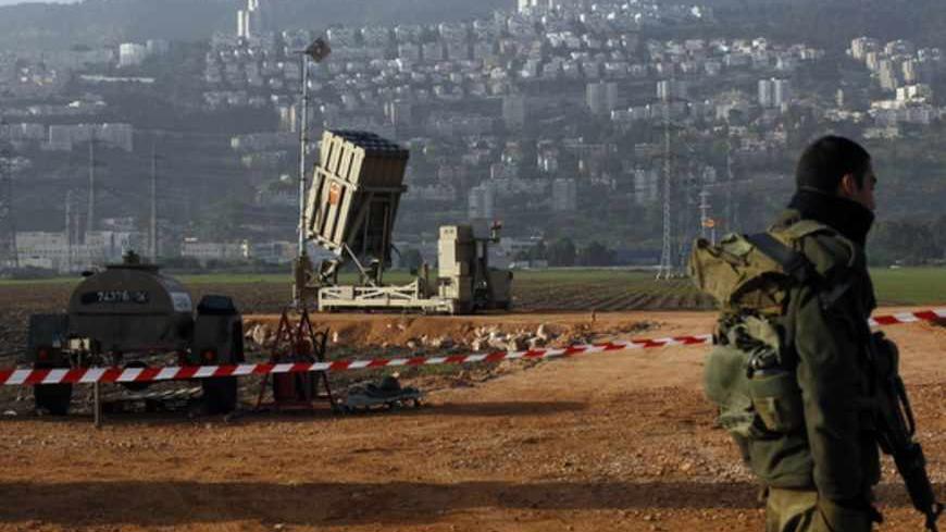 An Israeli soldier stands guard next to an Iron Dome rocket interceptor battery deployed near the northern Israeli city of Haifa January 28, 2013. Any sign that Syria's grip on its chemical weapons is slipping as it battles an armed uprising could trigger Israeli military strikes, Israel's vice premier said on Sunday. A military spokesman confirmed reports that two Iron Dome batteries were moved to the Haifa area but insisted this was part of a routine of rotating these systems. REUTERS/Baz Ratner (ISRAEL -