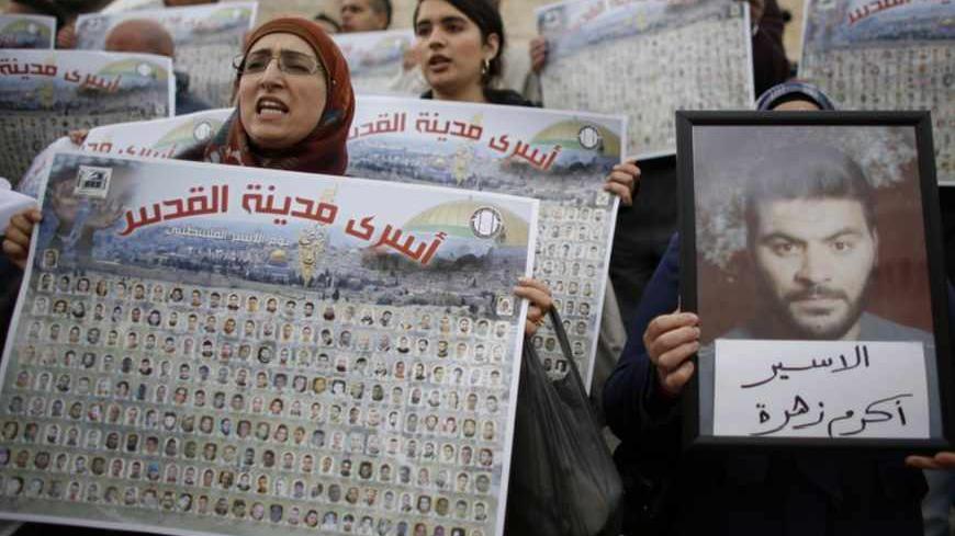Palestinians hold posters with pictures of Palestinian prisoners during a protest marking "Palestinian Prisoners Day" at Damascus Gate in Jerusalem's Old City April 17, 2013. "Prisoner Day", an annual commemoration of Palestinian prisoners jailed in Israel, who currently number 4,800, was held on Wednesday, with Israeli security forces on standby for possible protests. REUTERS/Ammar Awad (JERUSALEM - Tags: CIVIL UNREST POLITICS) - RTXYPGD