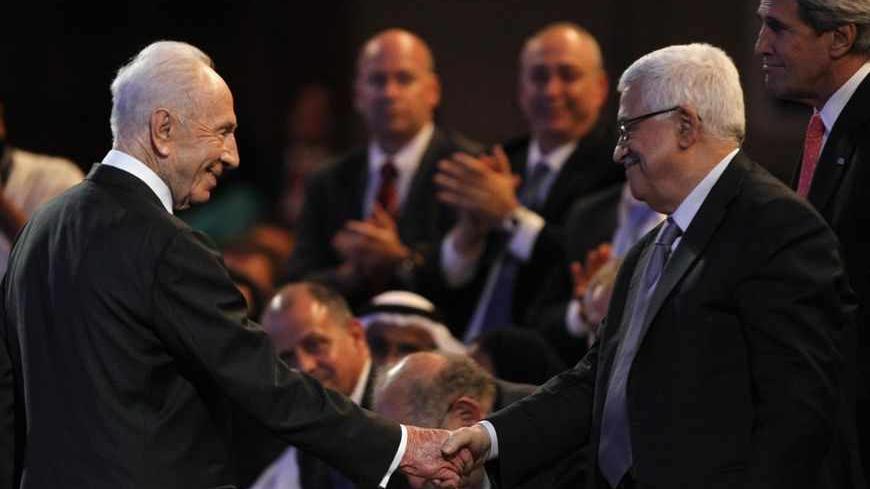 Israeli President Shimon Peres (L) shakes hands with Palestinian President Mahmoud Abbas as U.S. Secretary of State John Kerry (R) looks on, during the World Economic Forum on the Middle East and North Africa at the King Hussein Convention Centre, at the Dead Sea May 26, 2013. REUTERS/Muhammad Hamed (JORDAN - Tags: POLITICS BUSINESS) - RTX10258