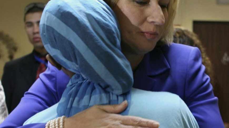 Israel's Foreign Minister Tzipi Livni (R) hugs a woman living in a shelter for battered women in Jerusalem November 25, 2008. Tuesday marks the International Day for the Elimination of Violence against Women. REUTERS/Eliana Aponte (JERUSALEM) - RTXAYH7