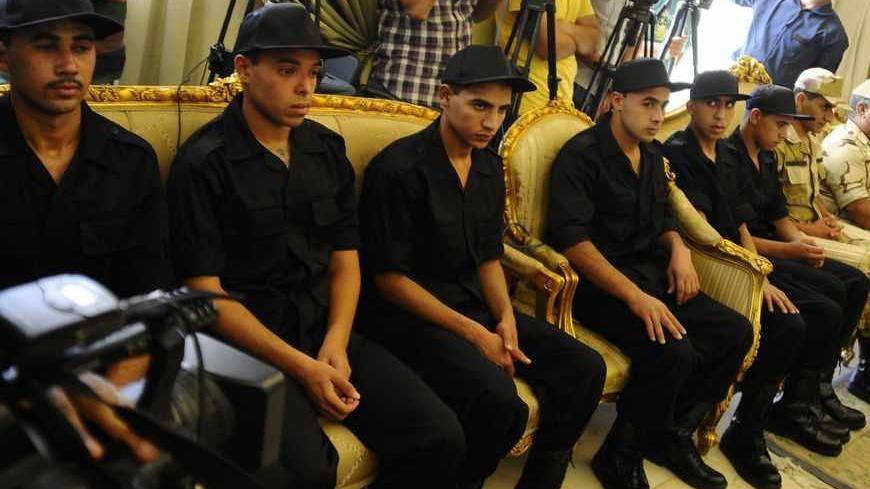 Soldiers who were kidnapped last week sit before a news conference by President Mohamed Mursi after their release, in Cairo, May 22, 2013. Seven members of the Egyptian security forces kidnapped by Islamist militants in Sinai last week were freed on Wednesday and Mursi announced a new crackdown on lawlessness in the desert peninsula.  REUTERS/Stringer (EGYPT - Tags: POLITICS CIVIL UNREST) - RTXZWM1