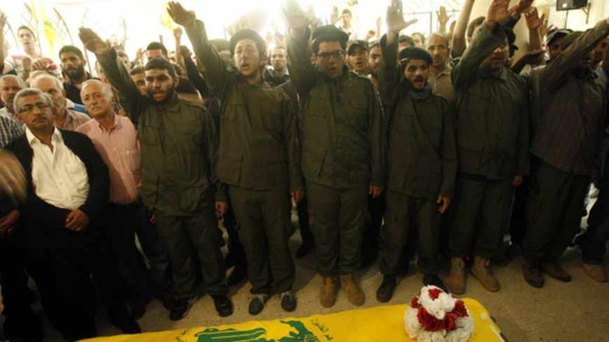 Members of Lebanon's of Hezbollah Shiite movement salute during the funeral of their comrade Saleh Ahmad Sabbagh in the southern Lebanese port city of Sidon on May 22, 2013. Local media said Sabbagh, the son of a Sunni father and a Shiite mother, who converted to Shiite Islam and joined Hezbollah years ago, was killed in the ongoing battle of Qusayr in the Syrian province of Homs.   AFP PHOTO/MAHMOUD ZAYYAT        (Photo credit should read MAHMOUD ZAYYAT/AFP/Getty Images)