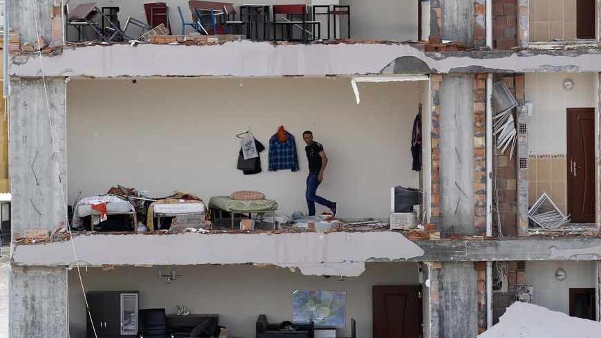 A man checks an apartment in a damaged building at the site of a blast in the town of Reyhanli in Hatay province, near the Turkish-Syrian border, May 13, 2013. Syria's information minister has blamed Turkey's government for deadly car bombings near the Syrian border and branded Prime Minister Tayyip Erdogan a "murderer", state-run Russian TV company RT reported on Monday. It said he repeated a denial of Syrian involvement in car bombings that killed 46 people on Saturday in the Turkish border town of Reyhan