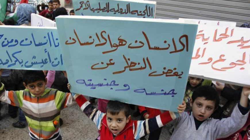 Palestinian children who were living in Yarmouk Palestinian refugee camp before fleeing Syria, hold banners during a protest in front of the International Committee of the Red Cross (ICRC) in Beirut  January 17, 2013. Banners read, "Man is man, regardless of gender and nationality" (C), "I am a human and I have the right to live with dignity" (L) and "We want protection from hunger and diseases".   REUTERS/Sharif Karim (LEBANON - Tags: SOCIETY IMMIGRATION POLITICS CONFLICT) - RTR3CK69