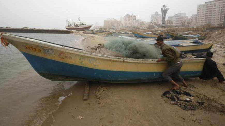 Palestinian fishermen push their boat at the seaport of Gaza City March 22, 2013. Hamas complained to Egypt on Friday after Israel suspended part of a Cairo-brokered truce agreement by halving Palestinian access to fishing waters in response to a rocket attack from the Gaza Strip.
REUTERS/Ibraheem Abu Mustafa (GAZA - Tags: POLITICS CIVIL UNREST BUSINESS) - RTR3FBUI