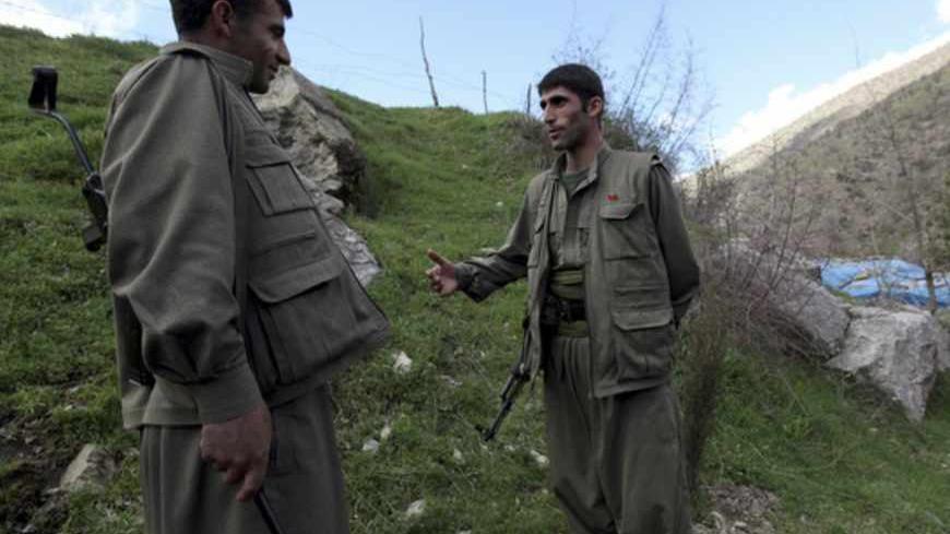 Kurdistan Workers Party (PKK) fighters talk to each other as they stand guard at the Qandil mountains near the Iraq-Turkish border in Sulaimaniya, 330 km (205 miles) northeast of Baghdad March 24, 2013. Shattered stone houses recall Turkish air strikes on Kurdish rebels holed up in the Qandil mountains of northern Iraq. Life is harsh amid the snowcapped peaks, supplies are sparse and armed forays across into Turkey perilous in the extreme. Yet rebel chief Abdullah Ocalan, who declared a ceasefire from his T