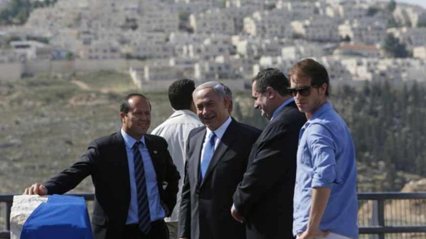 Israel's Prime Minister Benjamin Netanyahu (C) stands with Transport Minister Yisrael Katz (2nd R) and Jerusalem Mayor Nir Barkat (L) during an inauguration ceremony of a new highway connecting Pisgat Zeev, an urban settlement in an area Israel annexed to Jerusalem after capturing it in the 1967 Middle East war, with route 443, one of two main routes linking Israel's coastal plain with the uplands of Jerusalem, May 5, 2013. One of the highway's interchanges is named after Netanyahu's father, Benzion Netanya