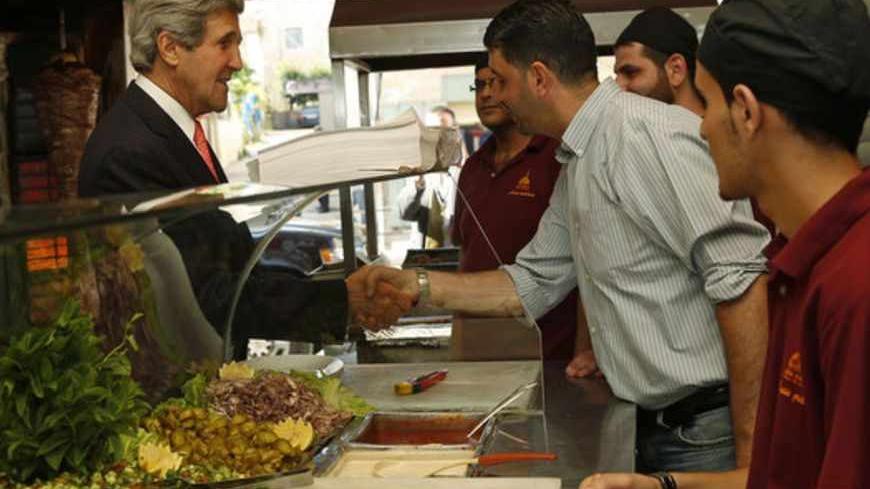 U.S. Secretary of State John Kerry greets workers as he visits a restaurant in the West Bank city of Ramallah, May 23, 2013.  REUTERS/Jim Young  (WEST BANK - Tags: POLITICS) - RTXZXXP