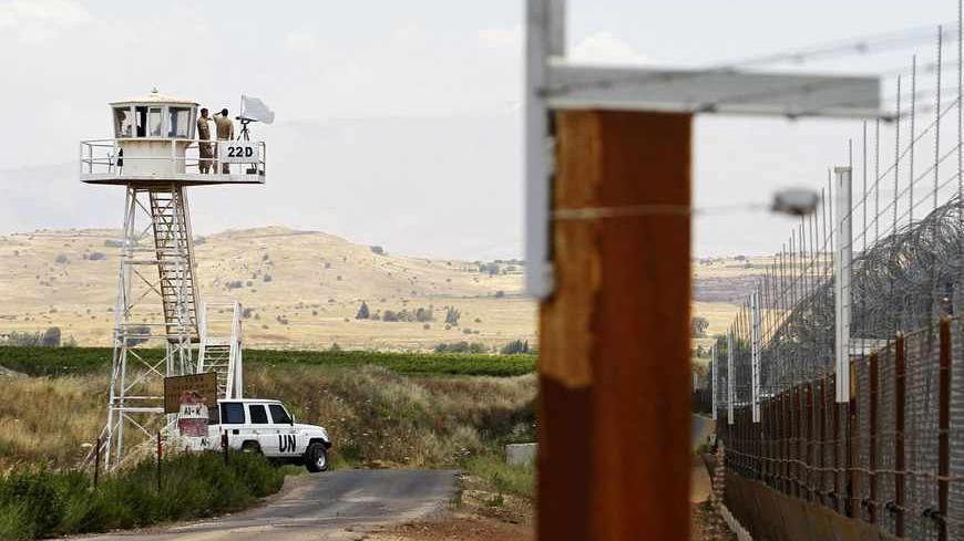 United Nations (U.N.) peacekeeping soldiers from Austria stand on an observation tower near the Quneitra border crossing between Israel and Syria, in the Israeli-occupied Golan Heights June 10, 2013. Syrian President Bashar al-Assad, backed by Iran and Lebanon's Hezbollah, may prevail in the more than two-year-old uprising against him, Israel's intelligence minister said on Monday. REUTERS/Baz Ratner (POLITICS) - RTX10ISS