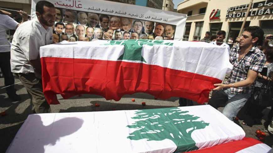 Protesters carry mock coffins draped with Lebanon's national flags, representing the parliament, as they express their refusal of the extension of parliamentary terms near the parliament in Beirut May 31, 2013. Lebanese lawmakers agreed on Friday to postpone a June parliamentary election until late next year due to instability in neighbouring Syria and political deadlock at home.  Words on the banner read, "You failed in everything. You failed, you failed, you failed... Go home!"   REUTERS/Sharif Karim (LEB