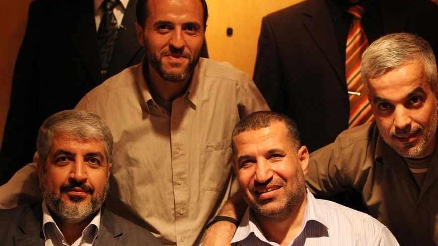 Hamas leader Khaled Meshaal (L) poses for photograph with Ahmed Al-Jabari (R), top commander of Hamas armed wing Al-Qassam brigades, and Palestinian prisoners (back) freed in a prisoner swap deal between Hamas and Israel, in Cairo October 18, 2011. Israeli soldier Gilad Shalit and hundreds of Palestinians crossed Israel's borders in opposite directions on Tuesday as a thousand-for-one prisoner exchange brought joy to families but did little to ease decades of conflict. REUTERS/Hamas Office/Handout (EGYPT - 