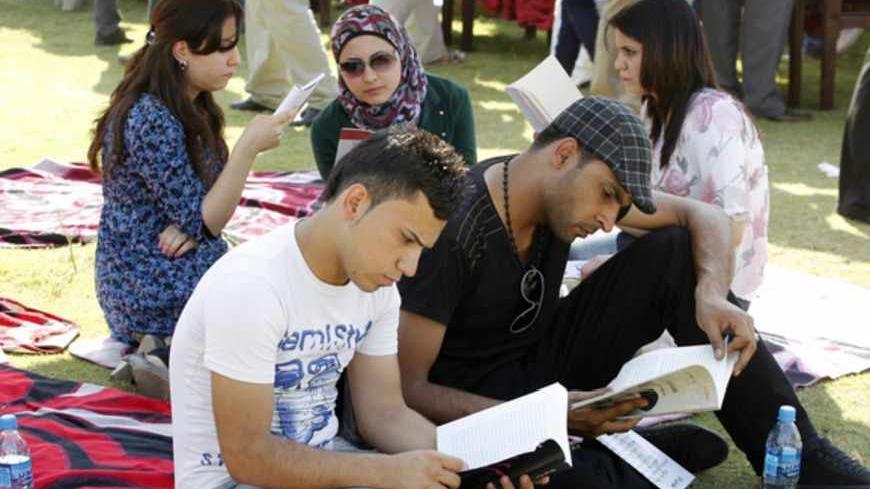 People read books during the launch of a reading initiative in Baghdad September 29, 2012. The "I am Iraqi... I read" initiative was launched by activists on Saturday in Baghdad to encourage Iraqis to read in a country that had suffered decades of war and internal struggle. Picture taken September 29, 2012. REUTERS/Thaier al-Sudani (IRAQ - Tags: SOCIETY EDUCATION) - RTR38M7Q