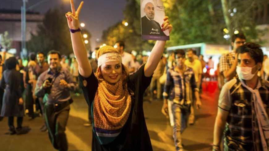 A supporter of moderate cleric Hassan Rohani gestures with a picture of him as she celebrates his victory in Iran's presidential election on a street in Tehran June 15, 2013. Rohani won Iran's presidential election on Saturday, the interior ministry said, scoring a surprising landslide victory over conservative hardliners without the need for a second round run-off. REUTERS/Fars News/Sina Shiri (IRAN - Tags: POLITICS ELECTIONS)  ATTENTION EDITORS - THIS IMAGE WAS PROVIDED BY A THIRD PARTY. FOR  EDITORIAL US