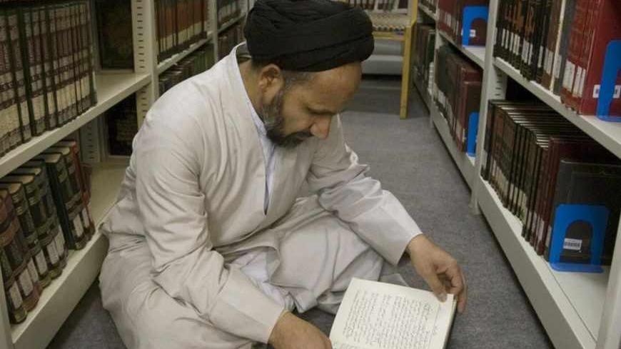 A cleric reads a book in the library of a religious research center associated with the seminary in Qom, 120 km (75 miles) south of Tehran February 2, 2009.     REUTERS/Caren Firouz  (IRAN) - RTXB5VE