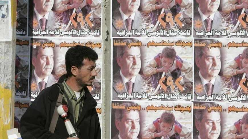 A resident walks past election campaign posters on Baghdad's Saadoun street January 3, 2009. The January 31 local election will apportion 440 seats on local councils that in turn name powerful regional governors.  REUTERS/Saad Shalash (IRAQ) - RTR230LK