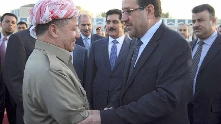 Iraqi Prime Minister Nuri al-Maliki (R) shakes hands with Iraqi Kurdish President Masoud Barzani (L) in Baghdad, July 7, 2013.  Barzani visited Baghdad on Sunday for the first time in more than two years, in a symbolic step to resolve disputes between the central government and the autonomous region over land and oil. The visit follows an equally rare trip by Iraqi Prime Minister Nuri al-Maliki who met Barzani in Kurdistan last month, breaking ice between leaders who have repeatedly accused each other of vi