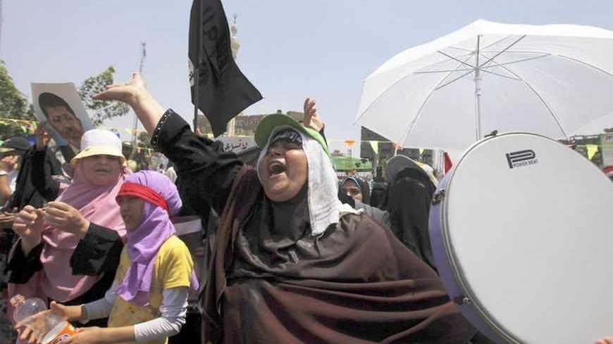Female members of the Muslim Brotherhood and supporters of deposed Egyptian President Mohamed Mursi with a drum and flags shout slogans as they rally at the Rabaa Adawiya square, where they are camping at, in Cairo July 11, 2013. Political infighting threatened to stall Egypt's transition plans on Thursday, as the military cracked down on Muslim Brotherhood leaders it blames for inciting a clash in Cairo in which troops shot and killed 53 protesters. Monday's violence between supporters of Mursi, Egypt's fi