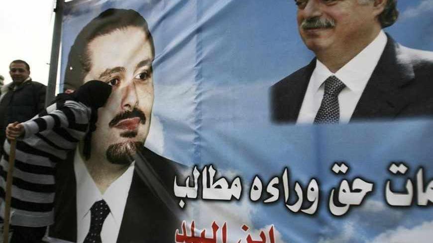 A Lebanese Sunni Muslim woman and supporter of Lebanon's caretaker Prime Minister Saad al-Hariri kisses a poster of him (L) and his father, assassinated former Prime Minister Rafik al-Hariri, during a protest in Tripoli, northern Lebanon, calling for Hariri to remain as prime minister and form the new government, January 24, 2011. Lebanese telecoms tycoon Najib Mikati, who is backed by Hezbollah and its allies, was set to lead a new government on Monday after winning support from Druze leader Walid Jumblatt