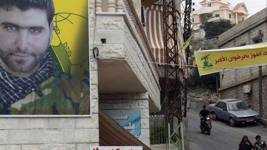 A poster of Mohamed Hassan Shehade, a Hezbollah fighter who died in the Syrian conflict, hangs on a building in Adloun town, south of Sidon in southern Lebanon, July 23, 2013. The European Union agreed on Monday to put the armed wing of Hezbollah on its terrorism blacklist, a move driven by concerns over the Lebanese militant group's involvement in a deadly bus bombing in Bulgaria and the Syrian war. REUTERS/Ali Hashisho    (LEBANON - Tags: POLITICS CIVIL UNREST MILITARY CRIME LAW) - RTX11W1Q