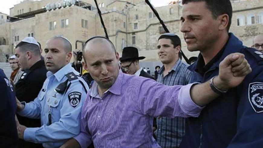 Naftali Bennett (C), leader of the Bayit Yehudi party, gestures as he leaves the Western Wall in Jerusalem's Old City ahead of Israel's parliamentary election on Tuesday, January 21, 2013. Bennett, leader of this far-right party, has emerged as the surprise success story of the country's election campaign.  REUTERS/Ammar Awad (JERUSALEM - Tags: POLITICS ELECTIONS RELIGION) - RTR3CQYX