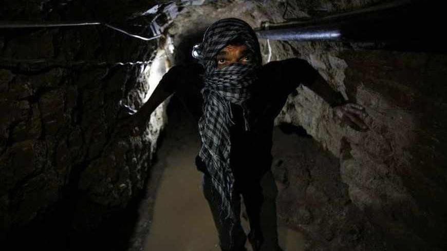 A Palestinian works inside a smuggling tunnel flooded by Egyptian forces, beneath the Egyptian-Gaza border in Rafah, in the southern Gaza Strip February 19, 2013. Egypt will not tolerate a two-way flow of smuggled arms with the Gaza Strip that is destabilising its Sinai peninsula, a senior aide to its Islamist president said, explaining why Egyptian forces flooded sub-border tunnels last week. To match Interview PALESTINIANS TUNNELS/EGYPT/      REUTERS/Ibraheem Abu Mustafa (GAZA - Tags: POLITICS CIVIL UNRES