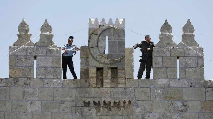 Israeli police officers stand guard atop a wall overlooking Damascus Gate in Jerusalem's Old City, during the holy month of Ramadan July 26, 2013. REUTERS/Baz Ratner (JERUSALEM - Tags: POLITICS RELIGION CRIME LAW) - RTX11ZWT